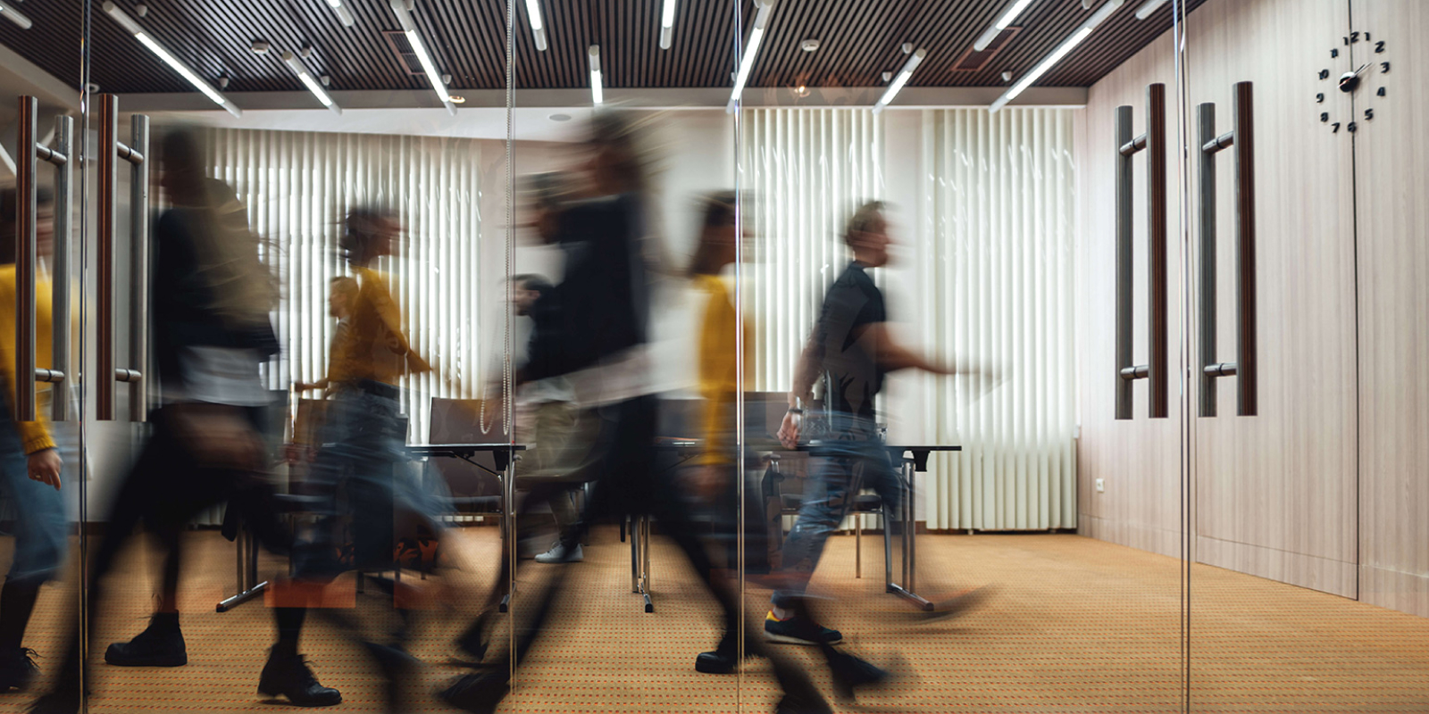Office room with blurred images of people walking back and forth